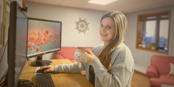 Happily providing website support while standing at desk and drinking tea